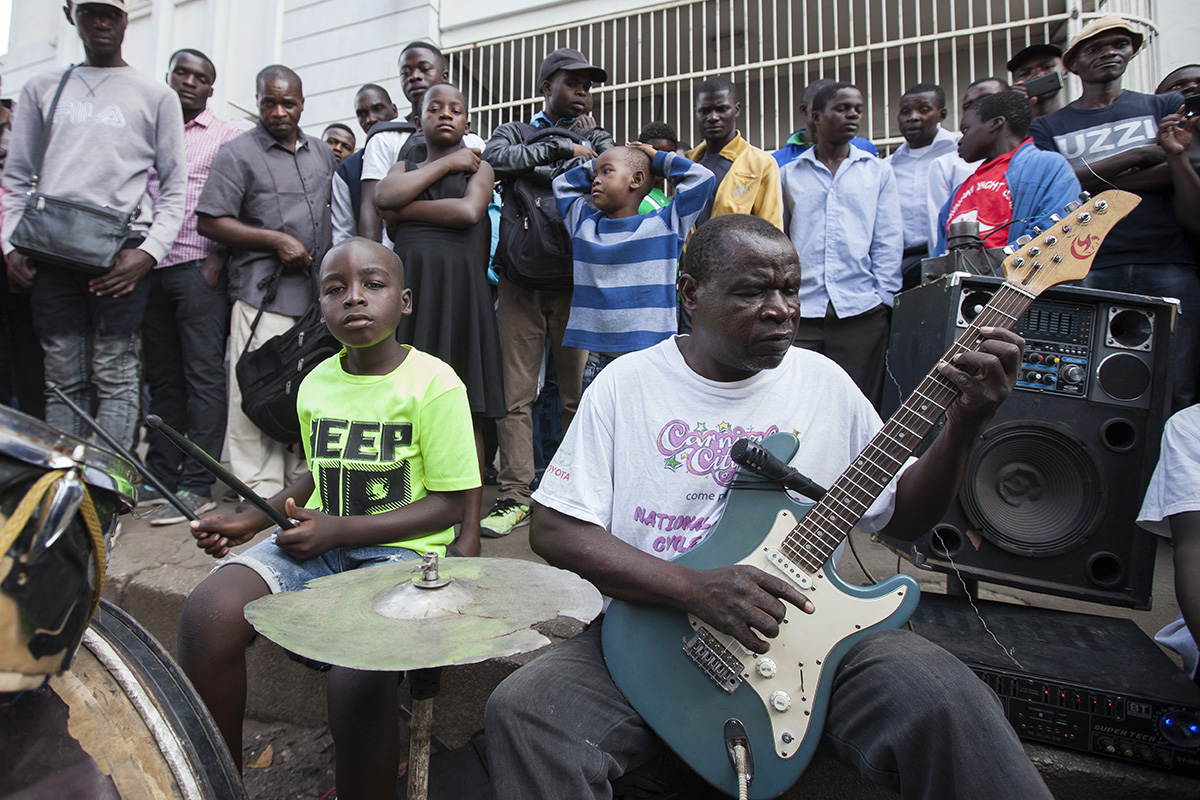 Zim Taguta Mundondo and son playing guitars on the street.jpg