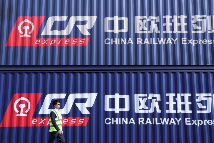 Mann går forbi kontainere i Tyskland. Illustrasjon av økt handel med den nye silkeveien. Foto: Xinhua