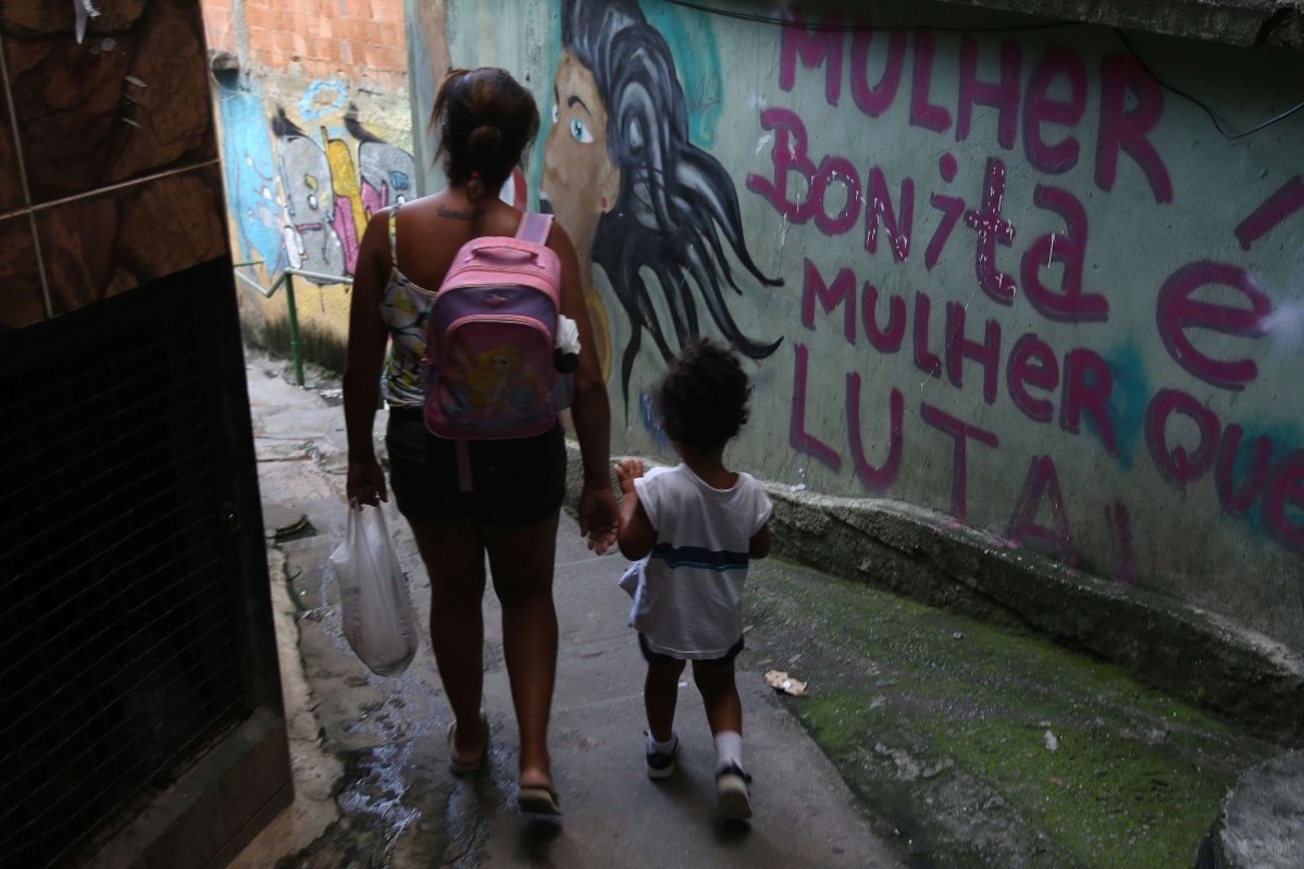 Mor og datter går gjennom et smug i en favela i Rio de Janeiro, Brasil