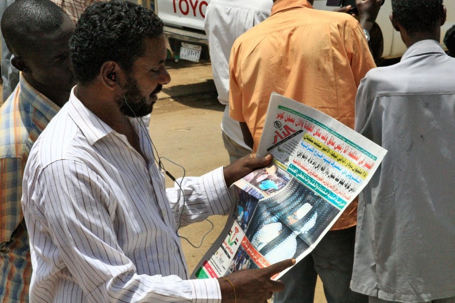 Mann leser avis som omtaler rettssak mot Omar al-Bashir i Sudan 20. august 2019.