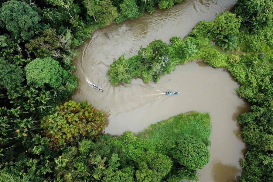 Bilde tatt fra drone av elv og regnskog, med båter. I Aceh i Indonesia.