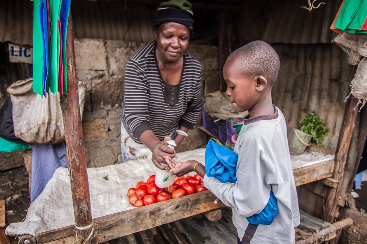 Kvinne i Kibera, Nairobi, selger grønnsaker.